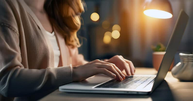 Woman typing on laptop at night